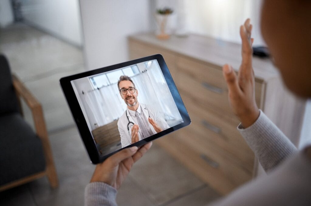 Ein Arzt berät einen Patienten auf einem Videogesprächsbildschirm für telemedizinische Therapie.